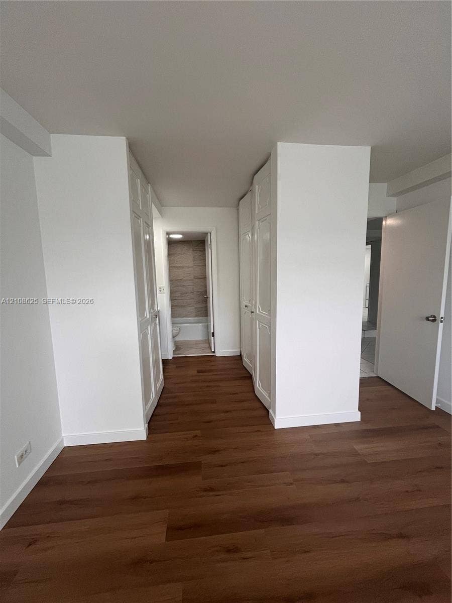 3650 Inverrary Drive, #1Q, Lauderhill, FL 33319 Interior space featuring wood-finish flooring, two sets of white panel doors, and neutral wall tones
