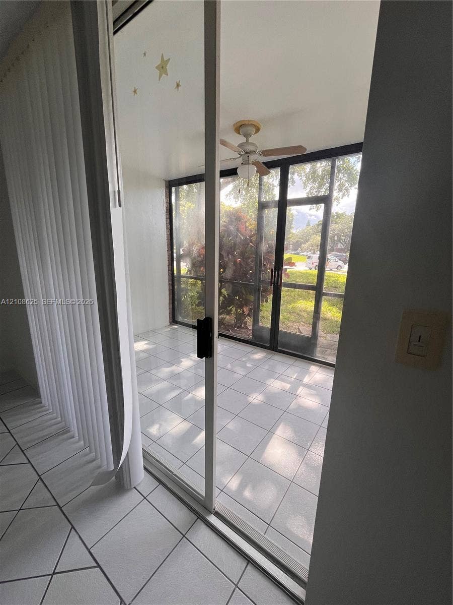 3650 Inverrary Drive, #1Q, Lauderhill, FL 33319 Enclosed patio featuring tile flooring, a ceiling fan, and black-framed screen panels