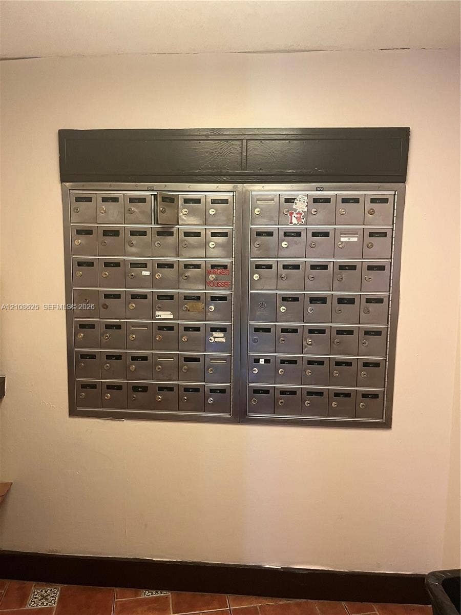 3650 Inverrary Drive, #1Q, Lauderhill, FL 33319 Wall-mounted cluster mailbox unit featuring dual stainless steel banks with individual key-locked compartments and dark-finish header trim