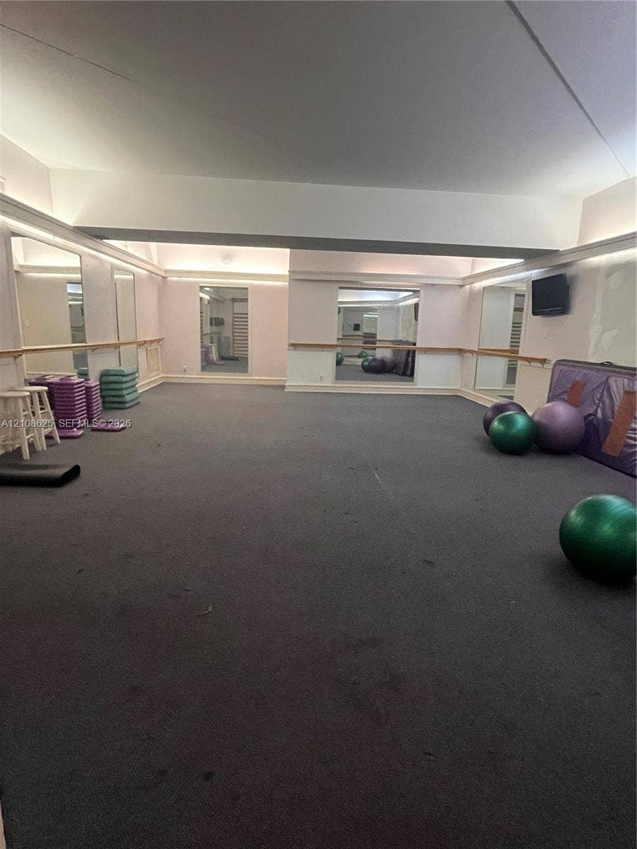 3650 Inverrary Drive, #1Q, Lauderhill, FL 33319 Spacious interior featuring full-length wall mirrors, integrated recessed lighting, and wall-mounted wooden ballet barres