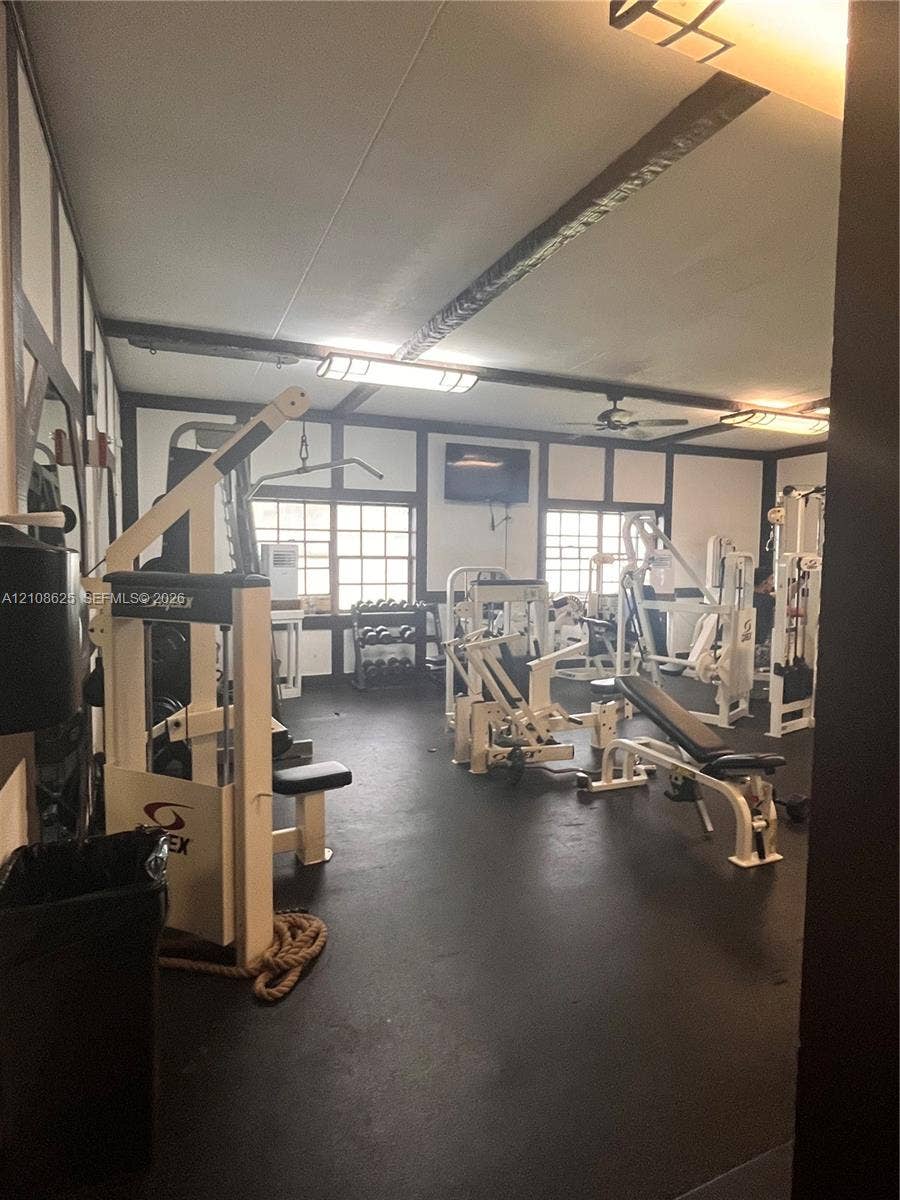 3650 Inverrary Drive, #1Q, Lauderhill, FL 33319 Interior space featuring half-timbered wall accents, dark resilient flooring, multi-pane windows, and linear overhead lighting