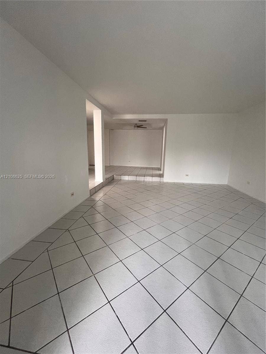 3650 Inverrary Drive, #1Q, Lauderhill, FL 33319 Spacious interior featuring large-format diagonal tile flooring, a recessed ceiling design, and elevated platform section