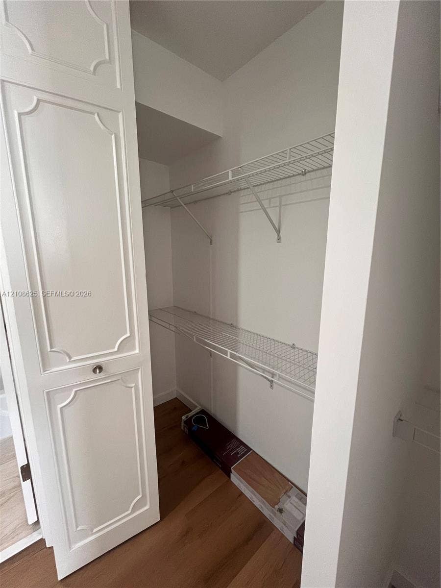 3650 Inverrary Drive, #1Q, Lauderhill, FL 33319 Closet featuring paneled doors, wood-finish flooring, and multi-level white wire shelving