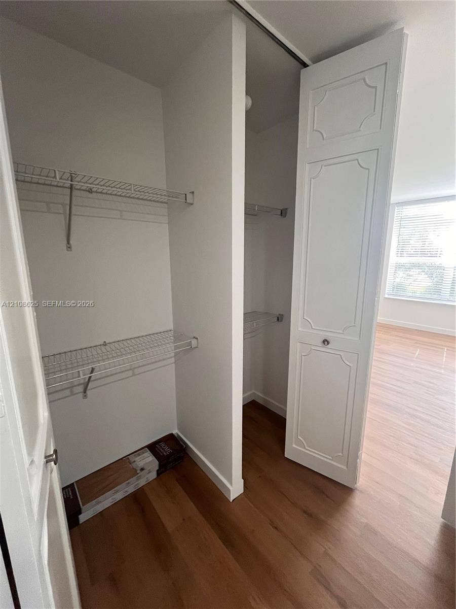 3650 Inverrary Drive, #1Q, Lauderhill, FL 33319 Walk-in closet featuring white paneled bi-fold doors, white interior walls, and multi-level wire shelving