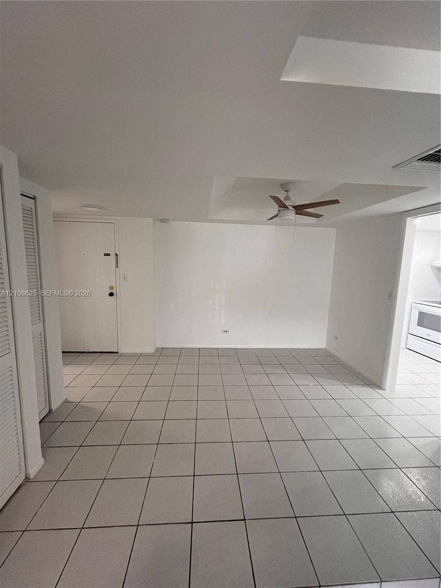 3650 Inverrary Drive, #1Q, Lauderhill, FL 33319 Neutral-toned tiled flooring, recessed ceiling with a mounted fan, and louvered closet doors