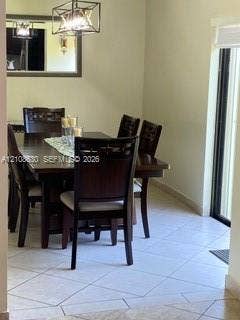 11511 SW 90th Terrace, Miami, FL 33176 Light-colored ceramic tile flooring, a geometric metal-frame chandelier, and a recessed wall mirror with a dark wood finish frame