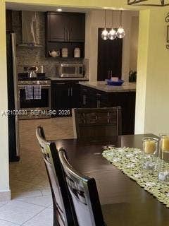 11511 SW 90th Terrace, Miami, FL 33176 Kitchen featuring dark-finish cabinetry, stone-surface countertops, stainless steel appliances, a center island, and pendant lighting
