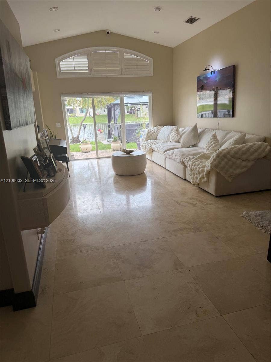 5032 SW 34th Terrace, Hollywood, Hollywood, FL 33312 Vaulted ceiling featuring recessed lighting, large-format stone tile flooring, arched clerestory window, and sliding glass doors