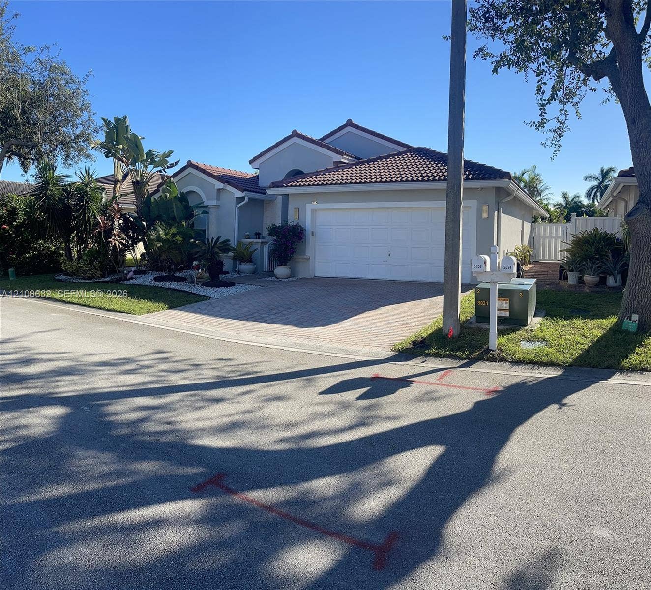 5032 SW 34th Terrace, Hollywood, Hollywood, FL 33312 Single-story residence featuring a tile roof, light-toned stucco exterior, two-car garage, and a paved driveway