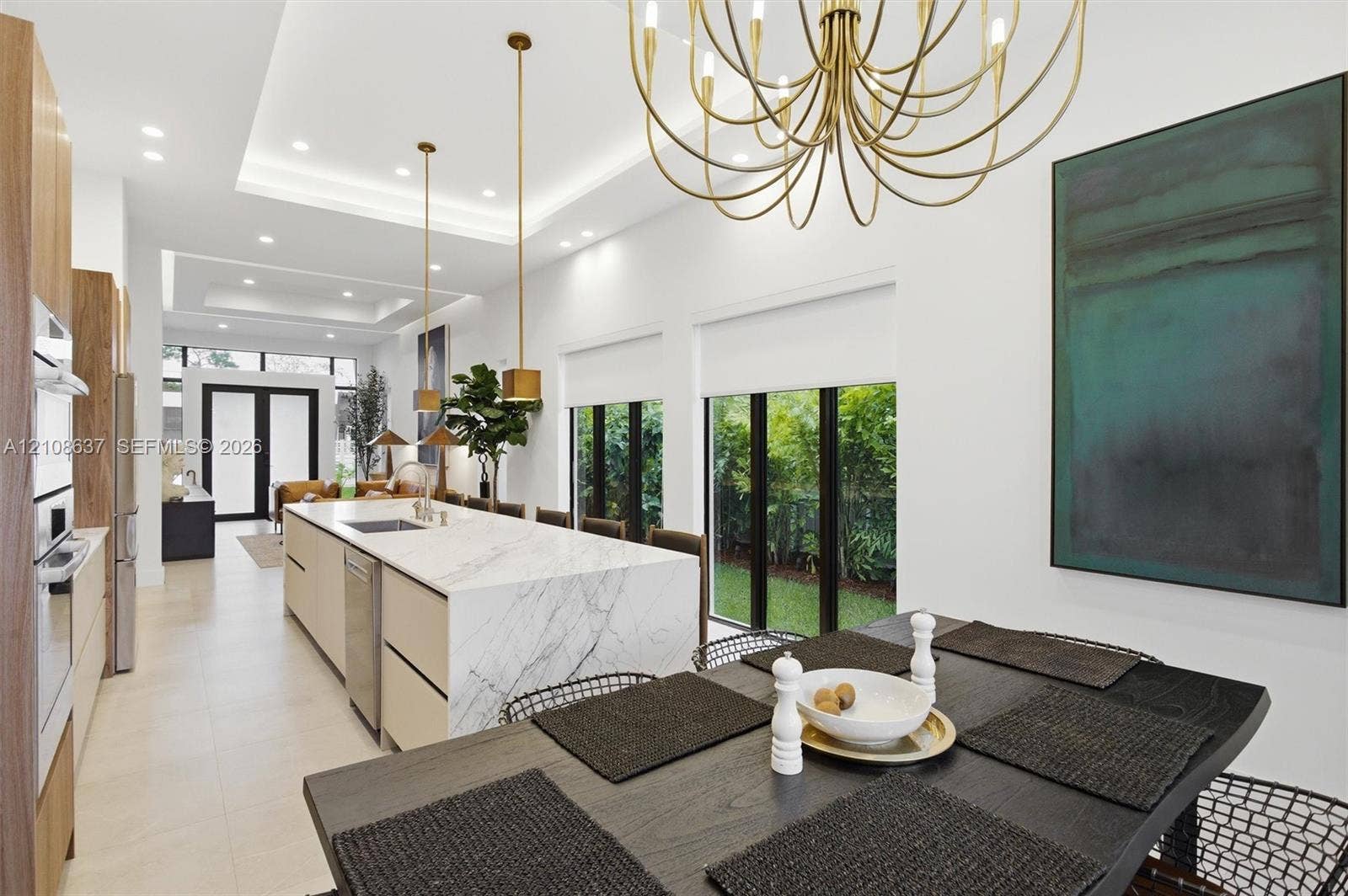 22900 SW 122nd Place, Miami, FL 33170 Kitchen featuring a waterfall island with stone-finish countertops, ceiling-recessed tray lighting, custom flat-panel cabinetry, metallic pendant lighting, and floor-to-ceiling windows