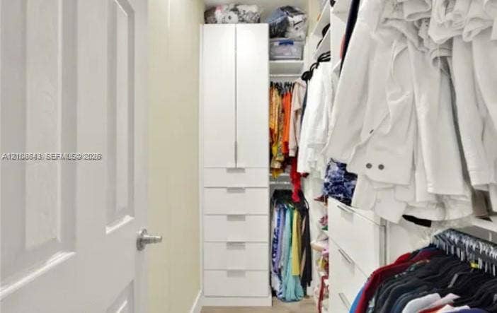 18815 SW 351 Street, Homestead, FL 33034 Walk-in closet featuring white built-in cabinetry, floor-to-ceiling storage, tiered shelving, and integrated drawers