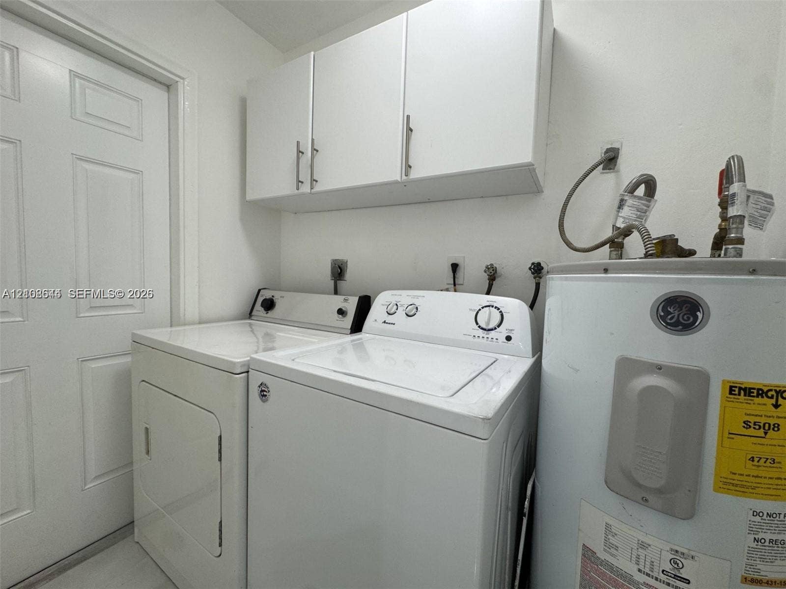 1431 N 14th Way, #rear, Hollywood, Hollywood, FL 33020 Utility area featuring white flat-panel upper cabinetry, a six-panel door, and dedicated washer and dryer hookups