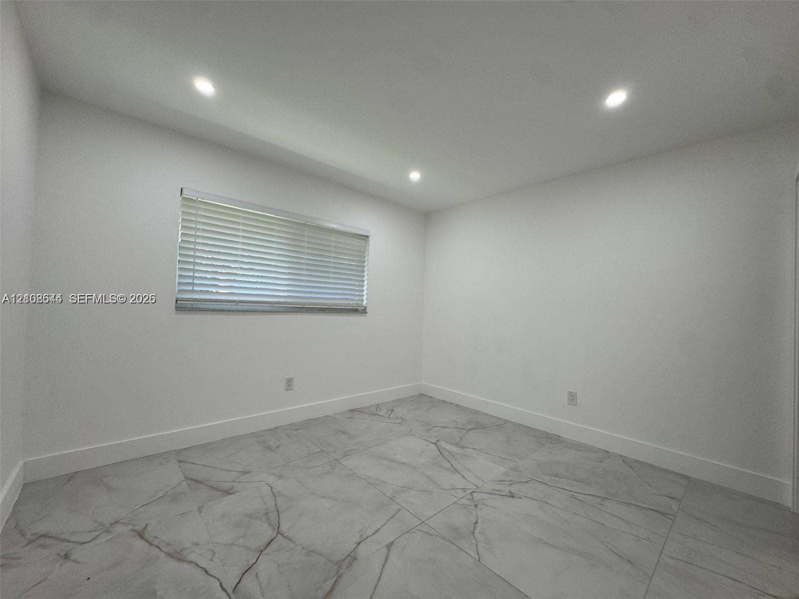 1431 N 14th Way, #rear, Hollywood, Hollywood, FL 33020 Interior room featuring large-format veined tile flooring, recessed ceiling lighting, and a single window with horizontal blinds