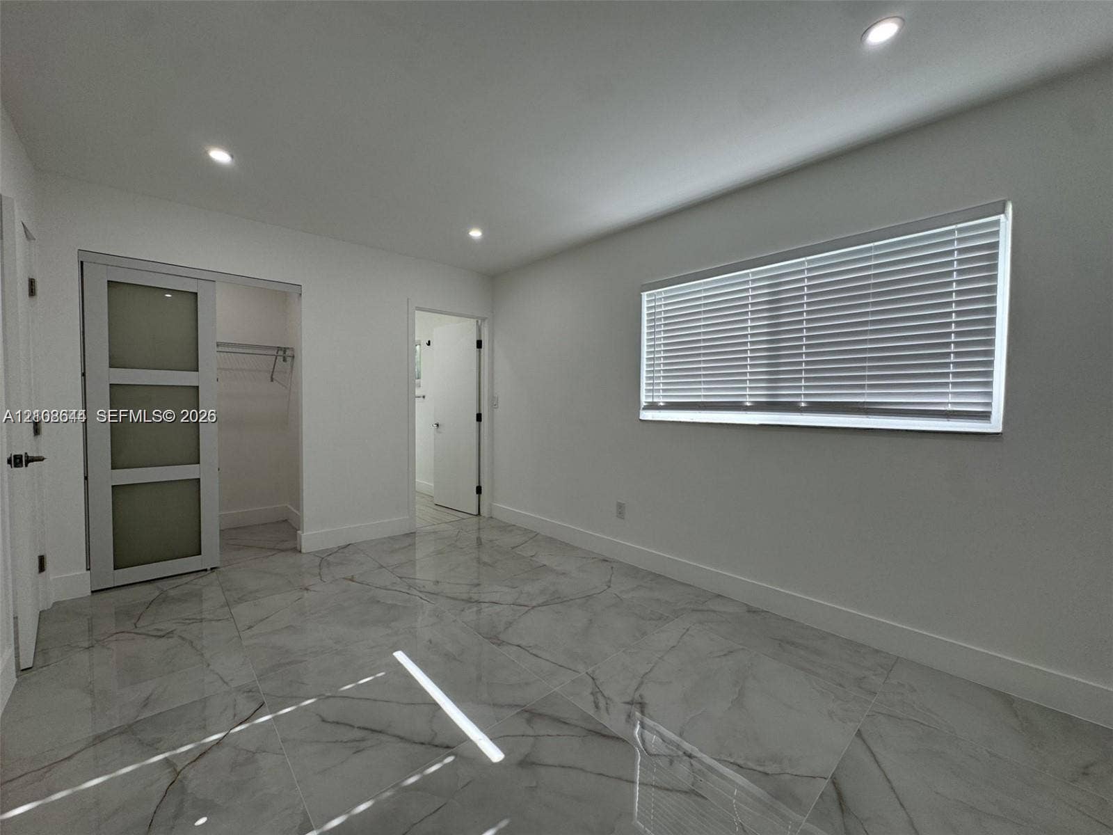 1431 N 14th Way, #rear, Hollywood, Hollywood, FL 33020 Large-format, veined tile flooring, recessed ceiling lighting, and a sliding barn-style door with frosted glass panels