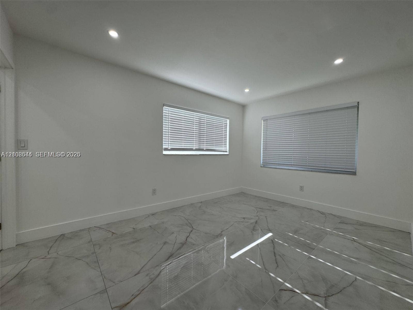 1431 N 14th Way, #rear, Hollywood, Hollywood, FL 33020 Room featuring large-format tile flooring with a veined pattern, recessed ceiling lighting, and two windows equipped with horizontal blinds