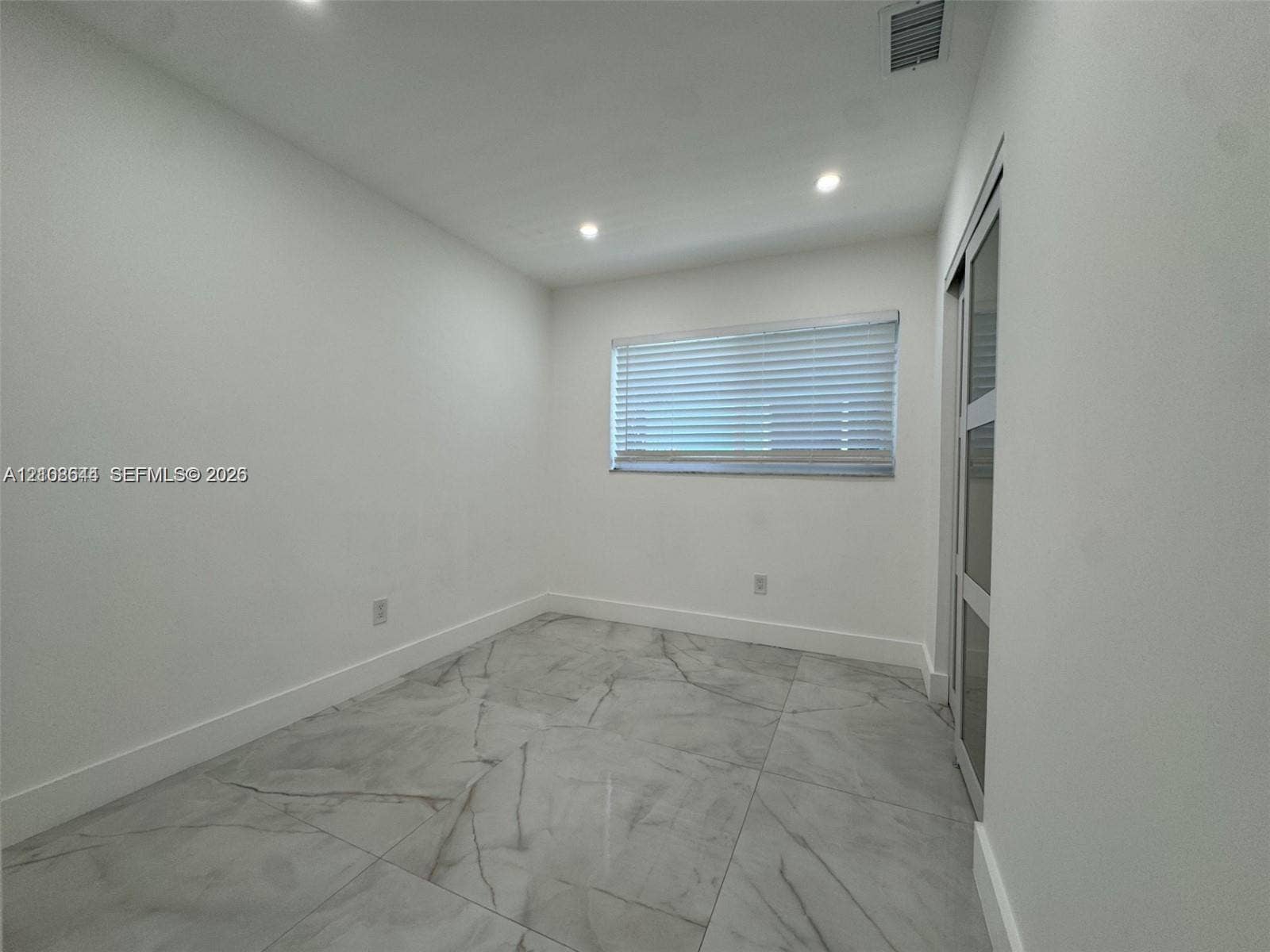 1431 N 14th Way, #rear, Hollywood, Hollywood, FL 33020 Interior space featuring large-format tile flooring, recessed lighting, and a sliding door with glass panels