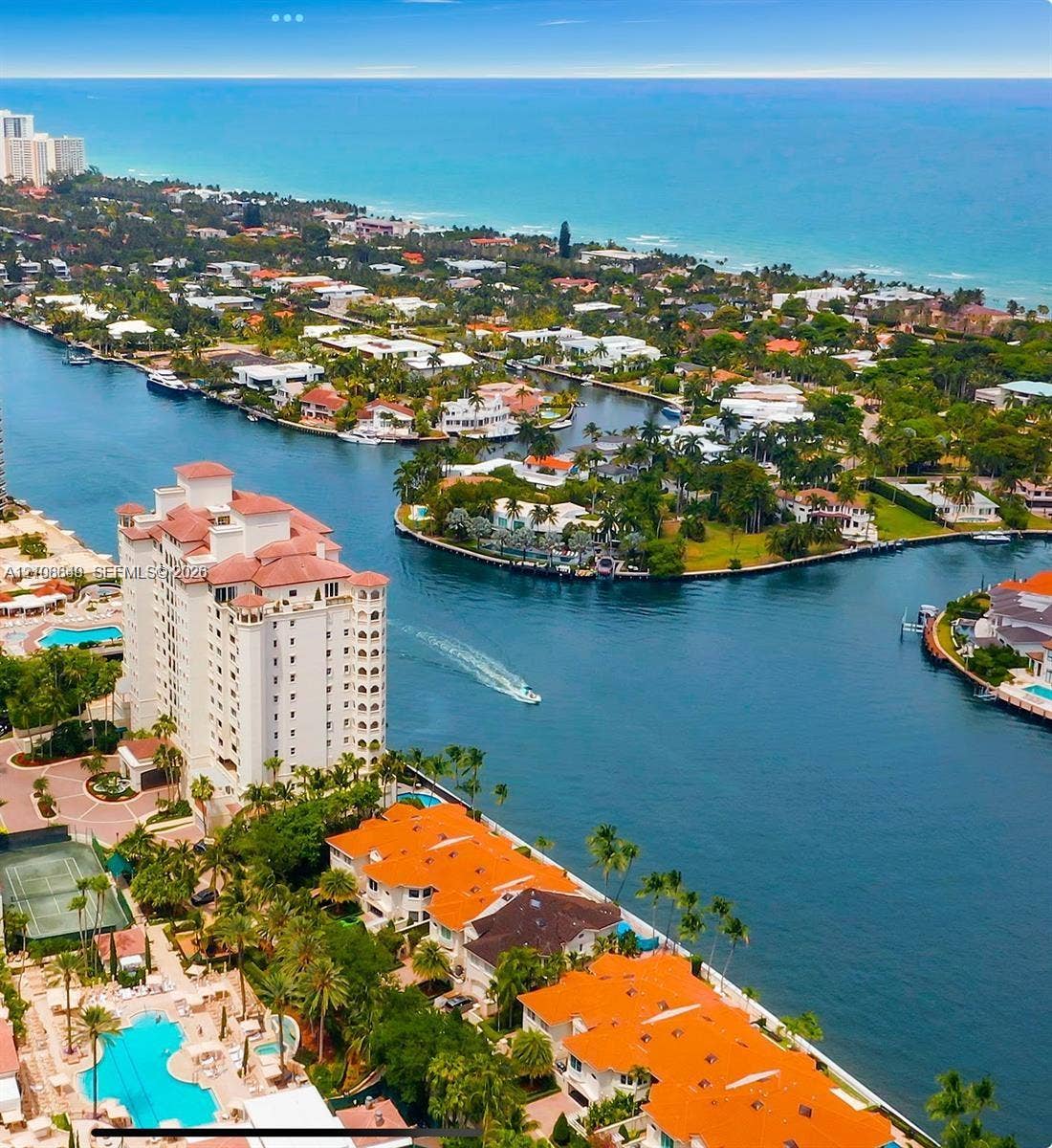 20165 NE 39 Place, #403, Aventura, FL 33180 Aerial perspective featuring waterfront residential structures, multi-story building, swimming pool, tennis court, and canal access
