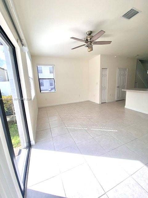 3288 W 106th Terrace, #3288, Hialeah, Hialeah, FL 33018 Open-concept interior featuring neutral tile flooring, recessed ceiling fan with integrated lighting, sliding glass door, and bi-fold closet doors