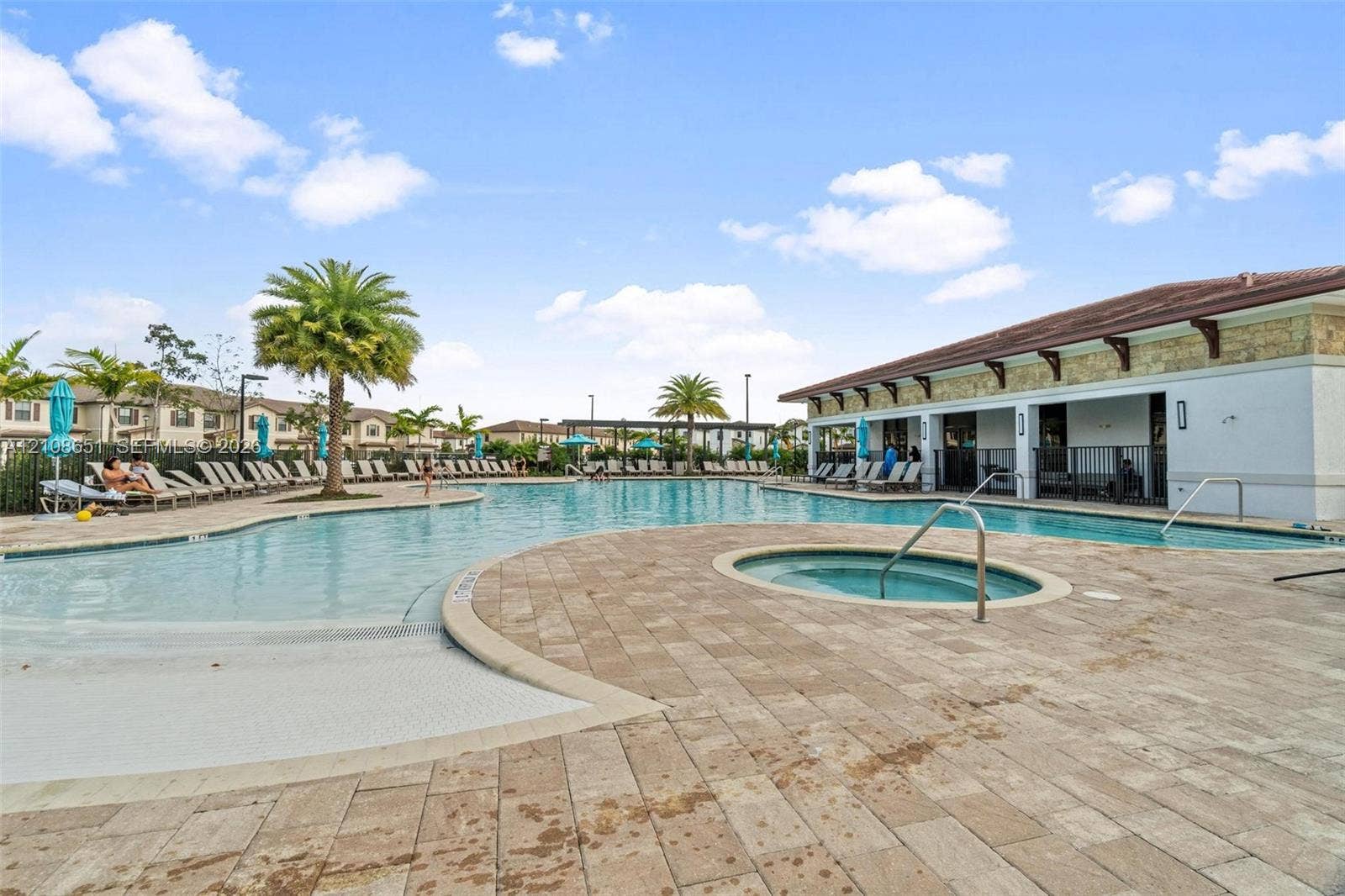 3288 W 106th Terrace, #3288, Hialeah, Hialeah, FL 33018 Community swimming pool featuring a zero-entry basin, integrated spa, and extensive paver decking