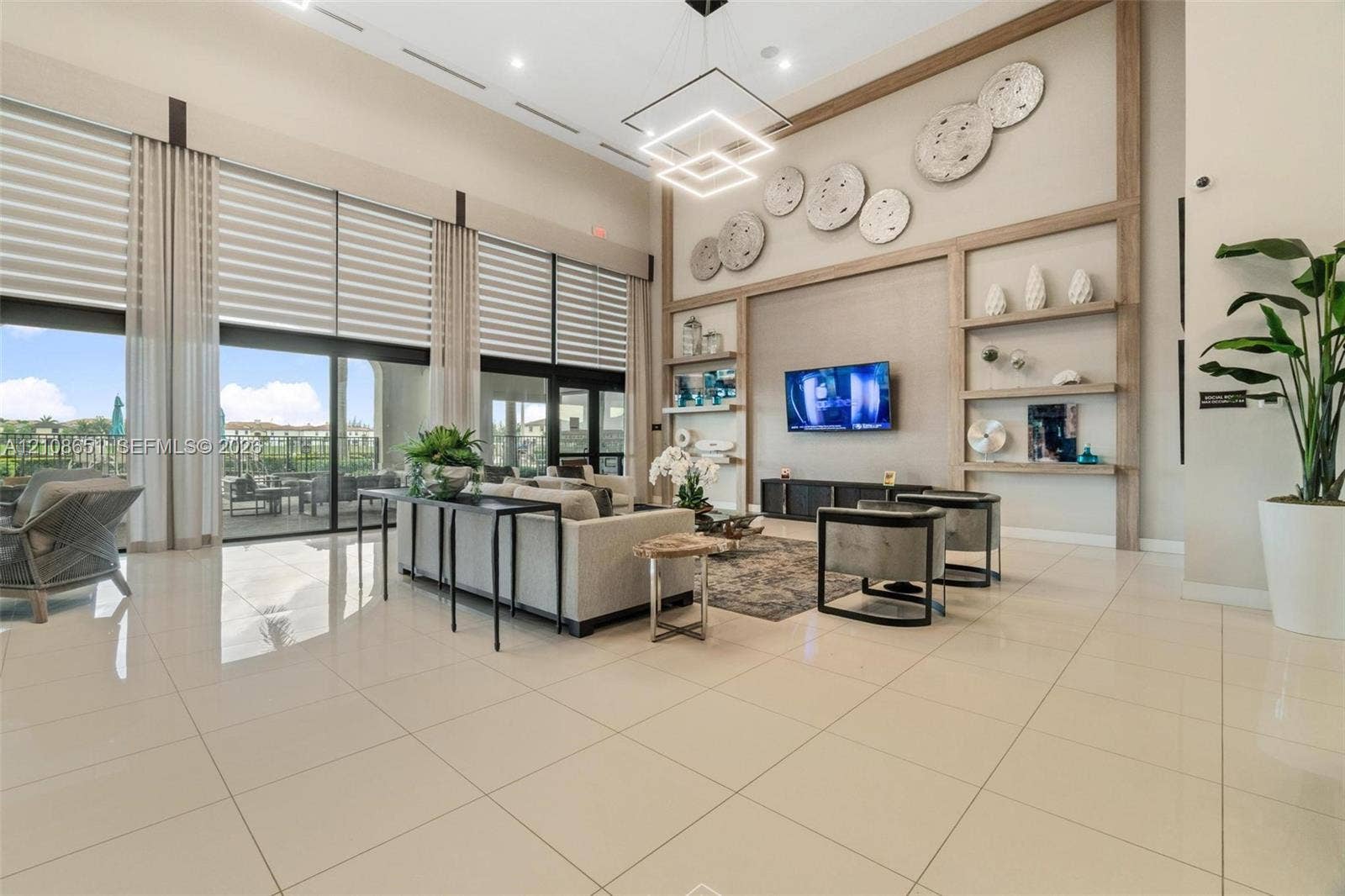 3288 W 106th Terrace, #3288, Hialeah, Hialeah, FL 33018 Great room with double-height ceilings, floor-to-ceiling glass wall, built-in wooden shelving, recessed lighting, and large-format tile flooring