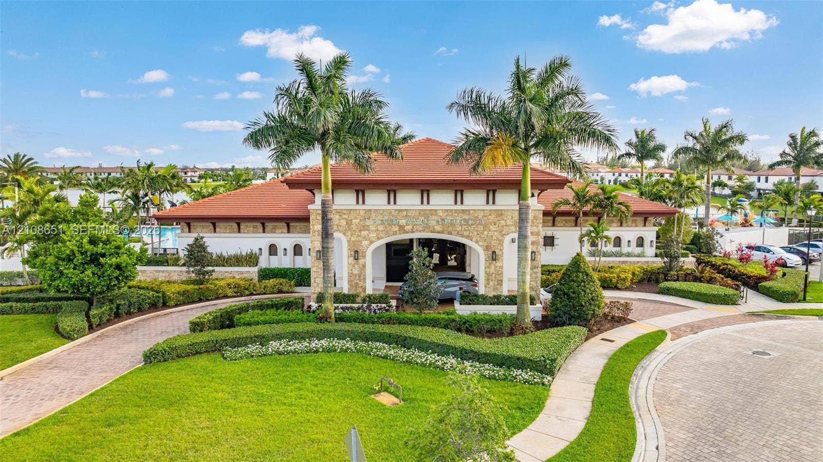3288 W 106th Terrace, #3288, Hialeah, Hialeah, FL 33018 Mediterranean-style exterior featuring stone veneer siding, a tile roof, a covered porte-cochre, and professionally manicured landscaping