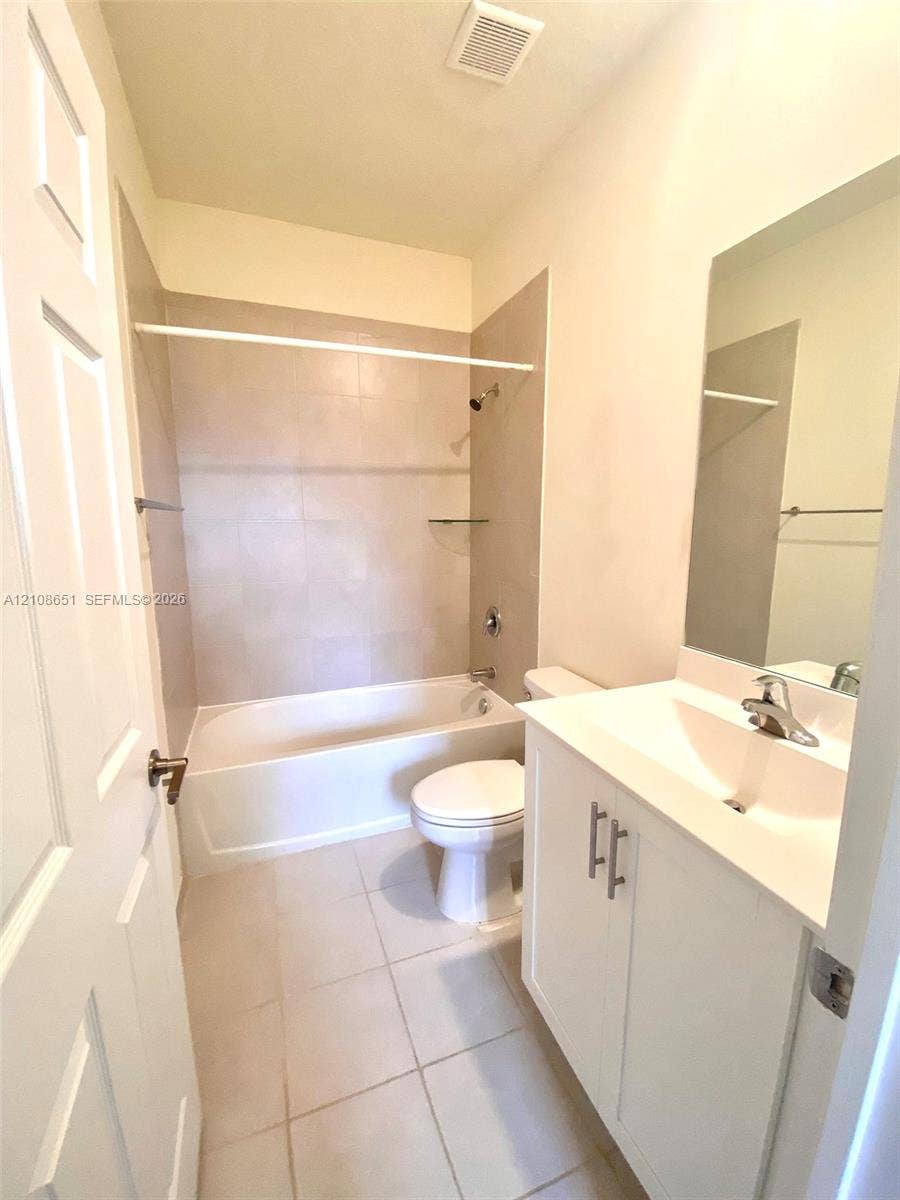 3288 W 106th Terrace, #3288, Hialeah, Hialeah, FL 33018 Bathroom featuring a vanity with white cabinetry and a molded sink, large wall-mounted mirror, tub-shower combination with light-toned tile surround, and neutral floor tile