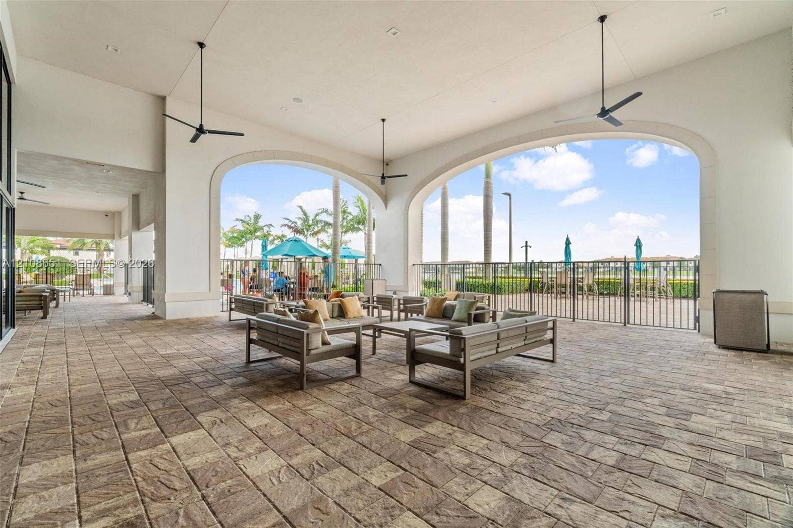 3288 W 106th Terrace, #3288, Hialeah, Hialeah, FL 33018 Covered patio featuring stone-paver flooring, multiple ceiling fans, and arched architectural openings