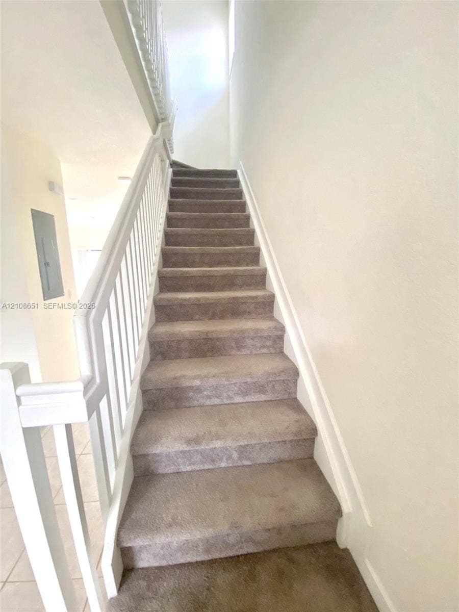 3288 W 106th Terrace, #3288, Hialeah, Hialeah, FL 33018 Staircase featuring neutral carpeting and white wooden handrails with vertical balusters
