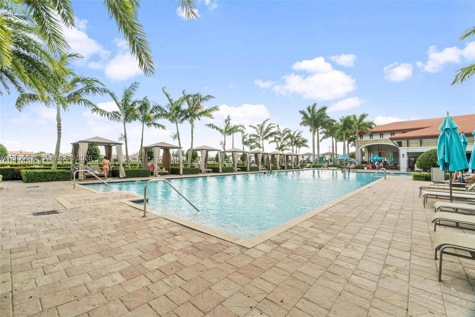 3288 W 106th Terrace, #3288, Hialeah, Hialeah, FL 33018 Rectangular swimming pool featuring a brick-paver deck, built-in covered cabanas, and mature palm trees