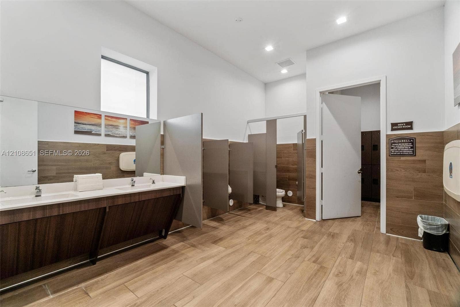 3288 W 106th Terrace, #3288, Hialeah, Hialeah, FL 33018 Restroom featuring wood-finish wall paneling, dual-basin vanity with a solid surface countertop, partition stalls, and recessed lighting