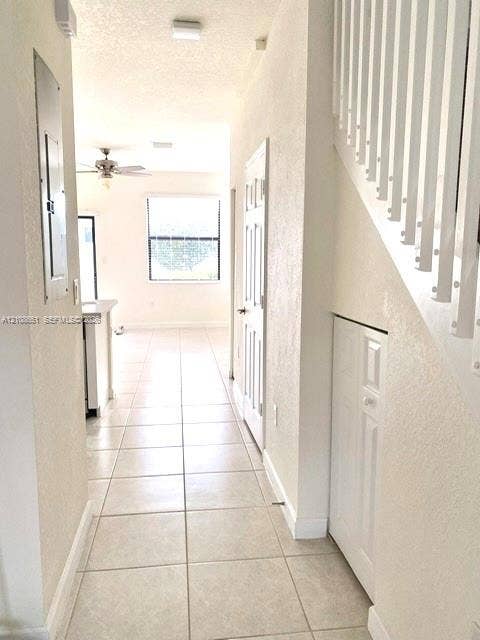 3288 W 106th Terrace, #3288, Hialeah, Hialeah, FL 33018 Ceramic tile flooring, white staircase with vertical balusters, and under-stair storage closet