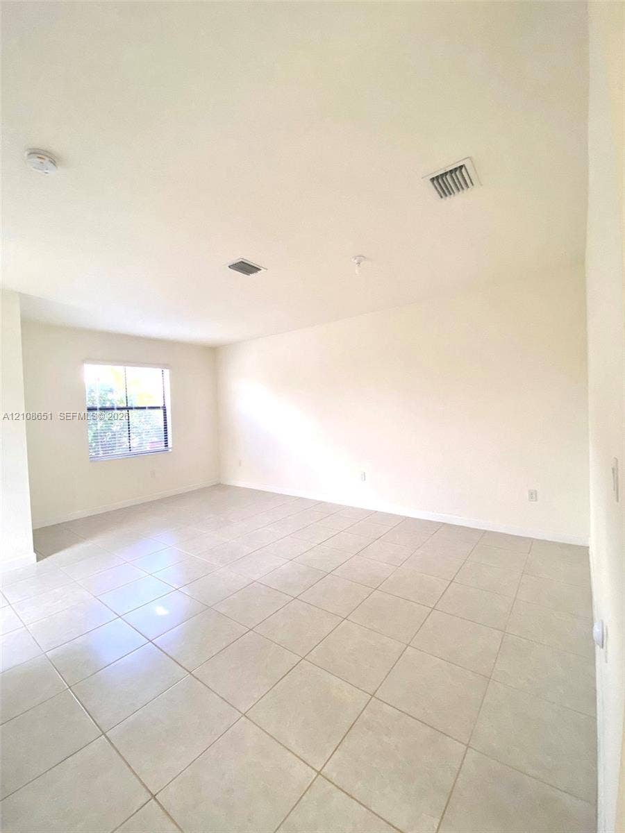 3288 W 106th Terrace, #3288, Hialeah, Hialeah, FL 33018 Neutral-toned ceramic tile flooring, crisp white walls, and a single-pane window with a grid pattern