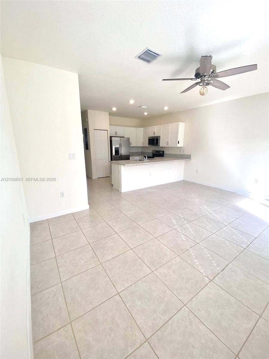 3288 W 106th Terrace, #3288, Hialeah, Hialeah, FL 33018 Kitchen featuring white cabinetry, solid-surface countertops, stainless steel appliances, tile flooring, and recessed ceiling lighting