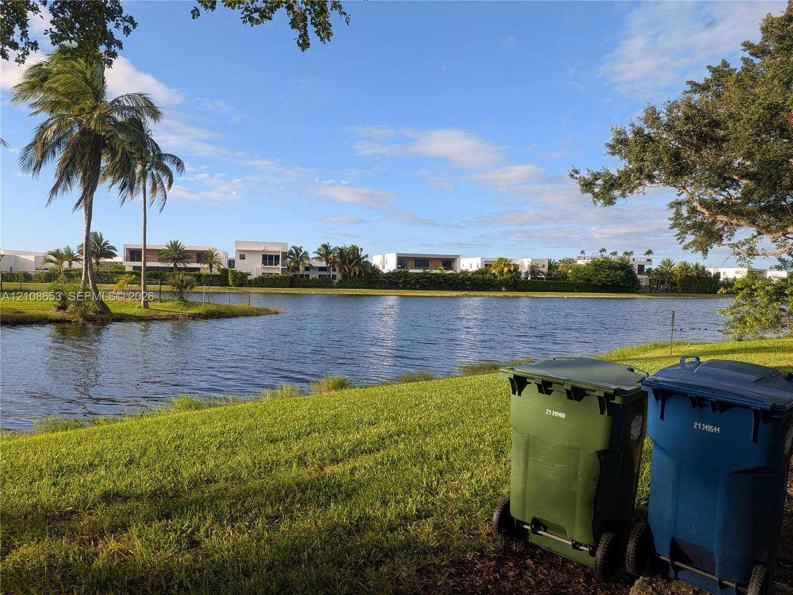 291 Duval Court, #0, Weston, Weston, FL 33326 Waterfront property featuring a grassy lawn, mature palm trees, and established landscaping