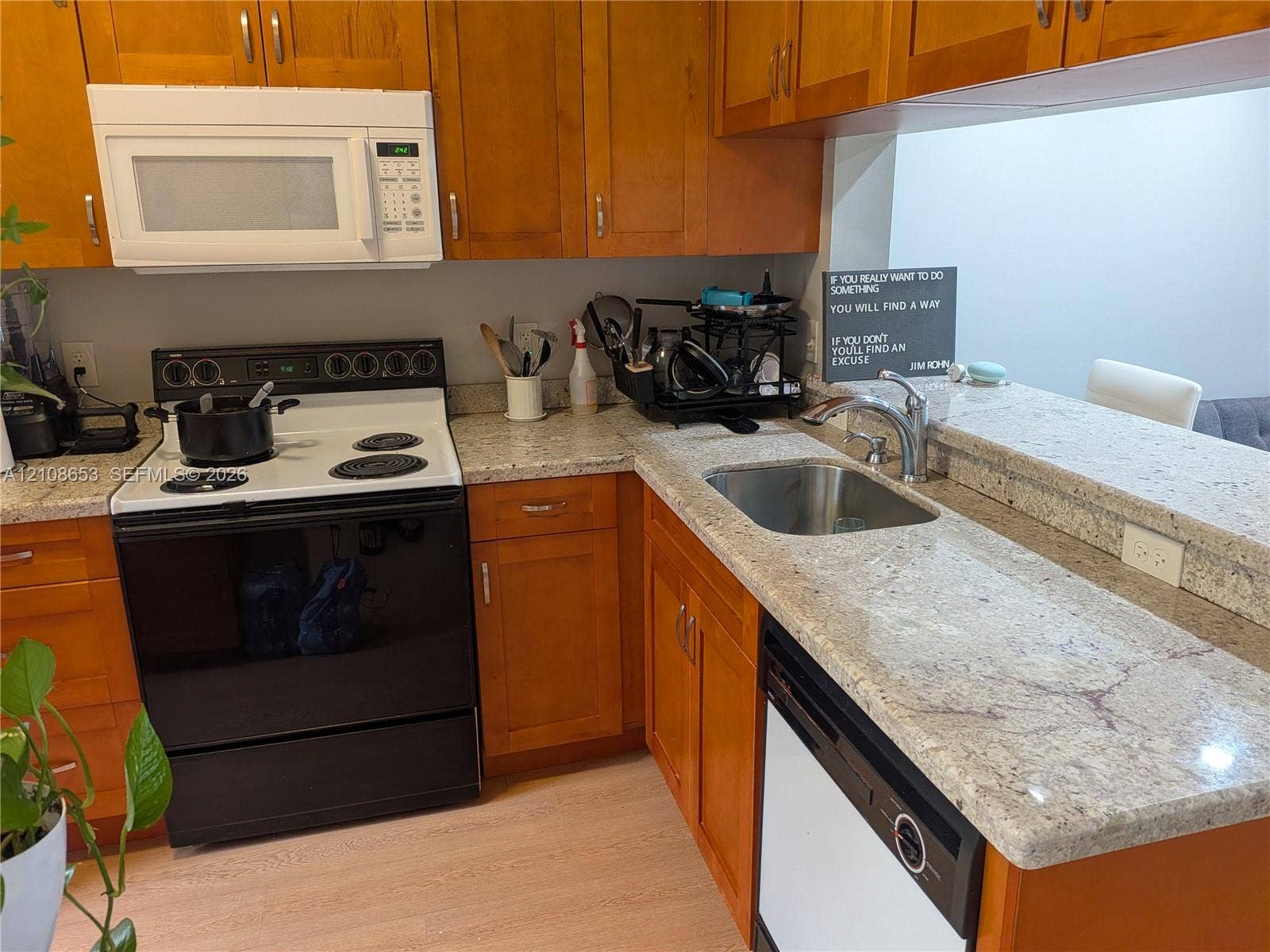 291 Duval Court, #0, Weston, Weston, FL 33326 Kitchen featuring natural wood cabinetry, stone-surface countertops, an undermount stainless steel sink, a built-in microwave, and light-toned flooring