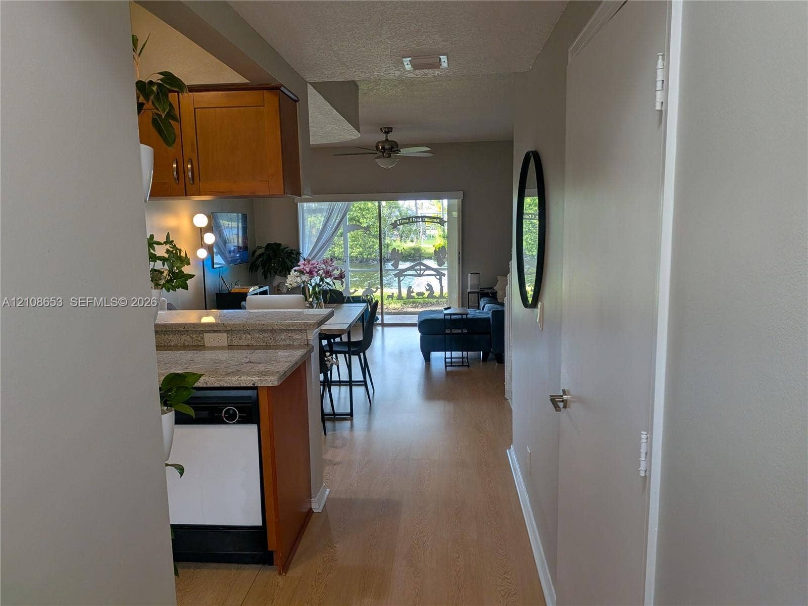 291 Duval Court, #0, Weston, Weston, FL 33326 Wood-finish flooring, kitchen cabinetry, stone-finish countertops, ceiling fan, and sliding glass door
