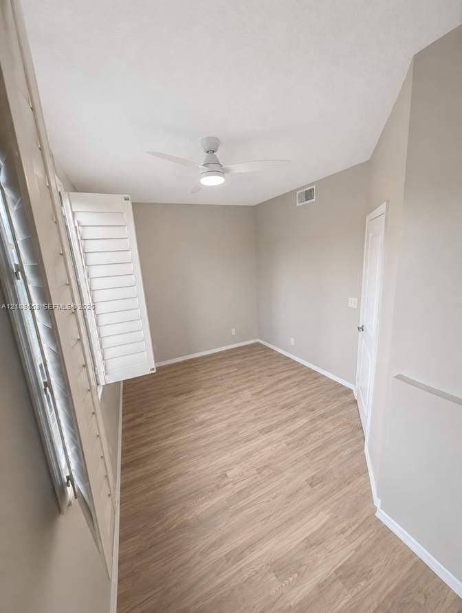 291 Duval Court, #0, Weston, Weston, FL 33326 Room featuring light-tone wood-finish flooring, white plantation shutters, a vaulted ceiling, and a modern ceiling fan with integrated lighting