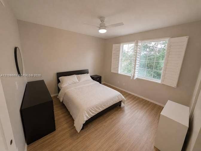 291 Duval Court, #0, Weston, Weston, FL 33326 Room featuring neutral paint, wood-finish flooring, white plantation shutters, and a ceiling fan with integrated lighting