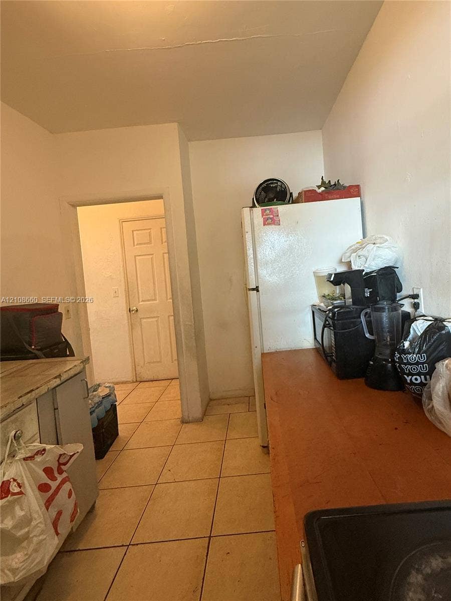 262 NE 111th Street, Miami, FL 33161 Kitchen area featuring tile flooring and a six-panel interior door
