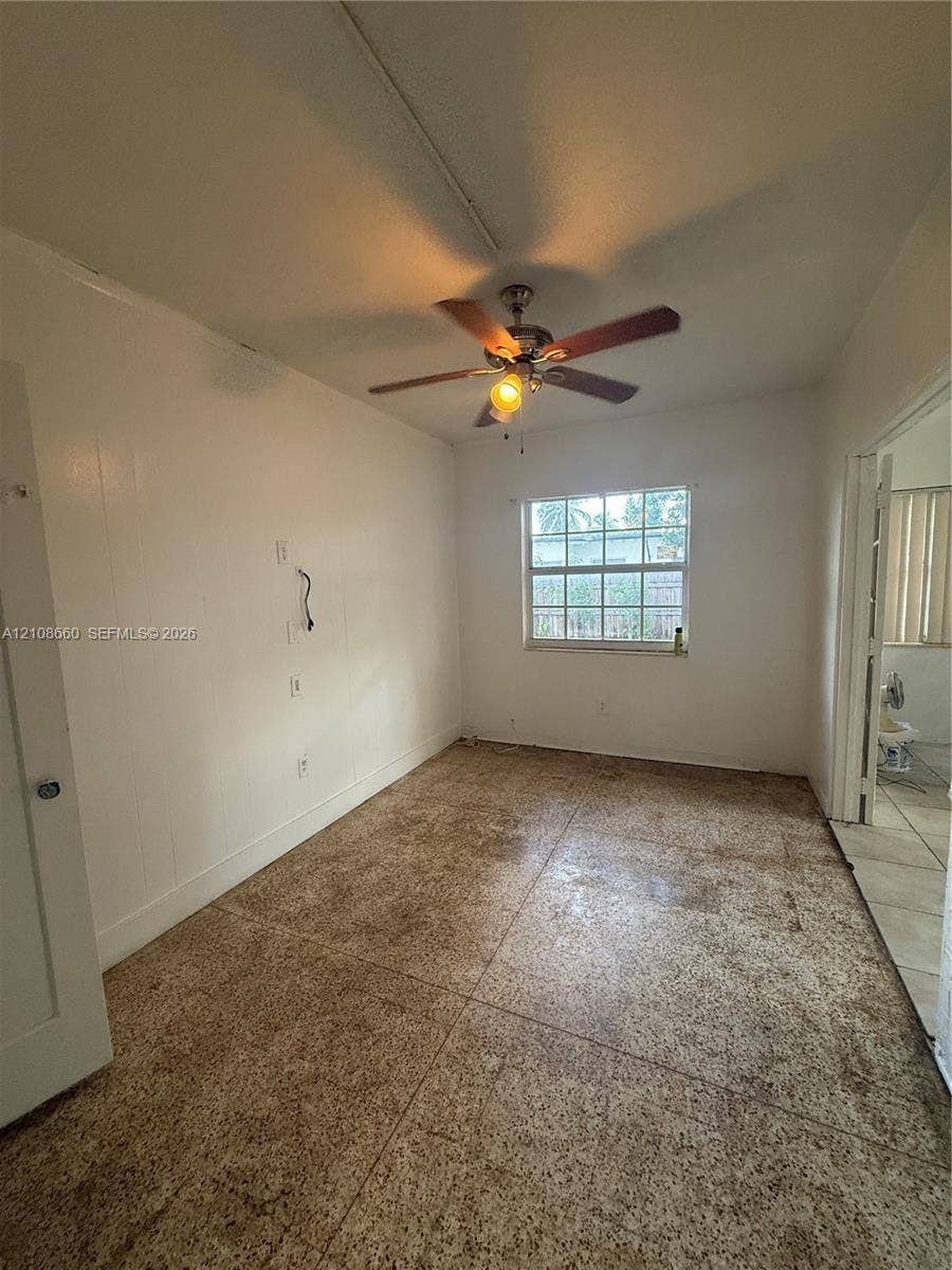 262 NE 111th Street, Miami, FL 33161 Interior space featuring tile flooring, a multi-blade ceiling fan with integrated lighting, and a single-pane window