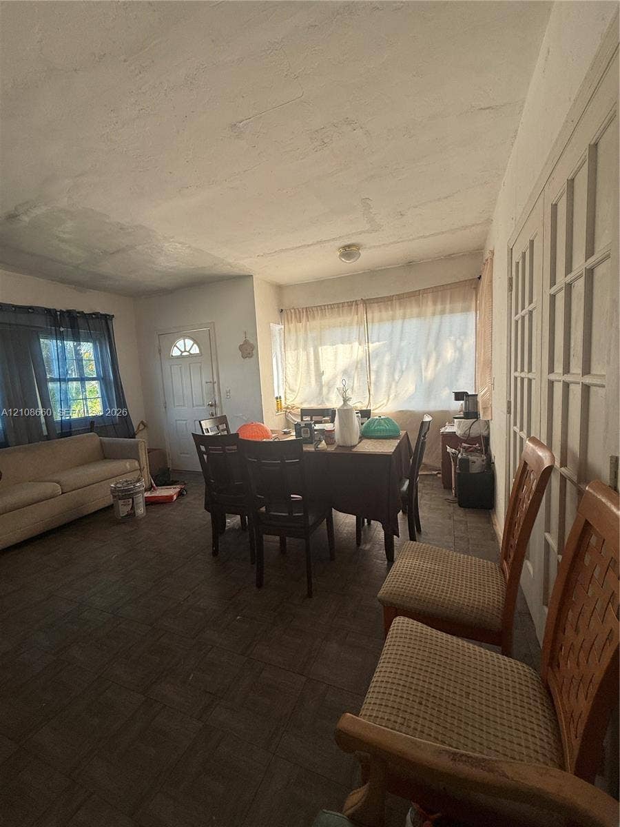 262 NE 111th Street, Miami, FL 33161 Interior space featuring square-pattern tile flooring, large windows, and multi-pane glass doors
