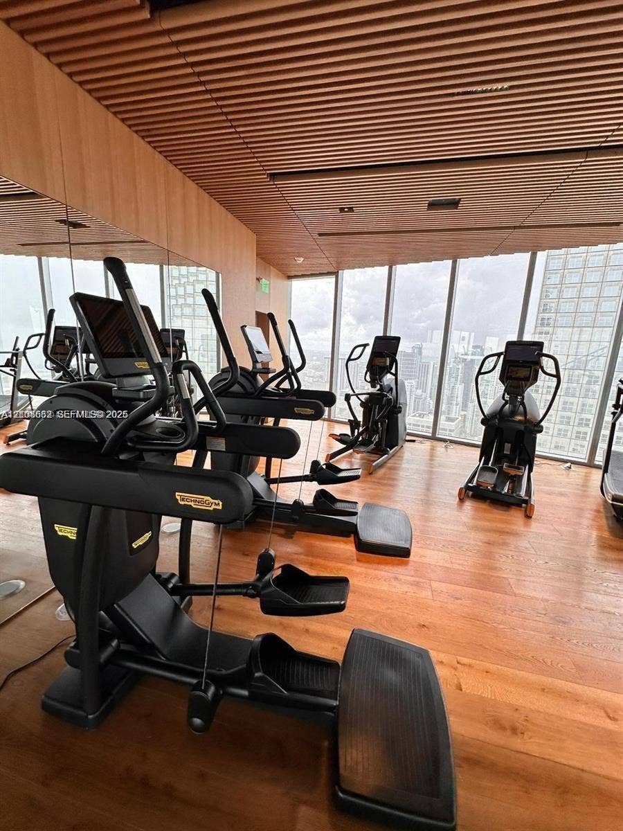 300 Biscayne Boulevard, #2709W, Miami, Miami, FL 33131 Fitness center featuring floor-to-ceiling windows, wood-finish flooring, and a linear slat ceiling design