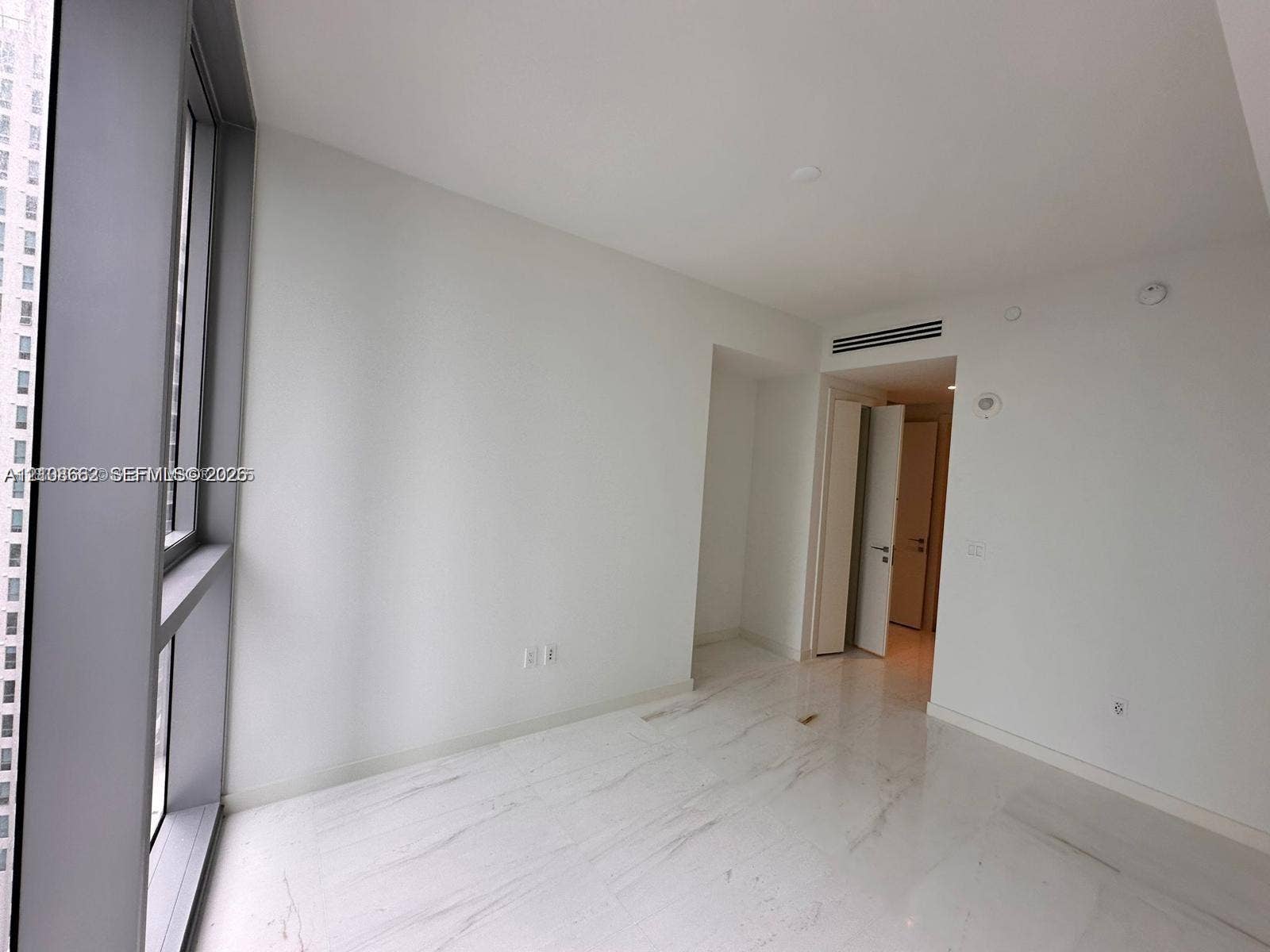 300 Biscayne Boulevard, #2709W, Miami, Miami, FL 33131 Floor-to-ceiling windows with metal framing, stone-finish flooring, and neutral wall tones