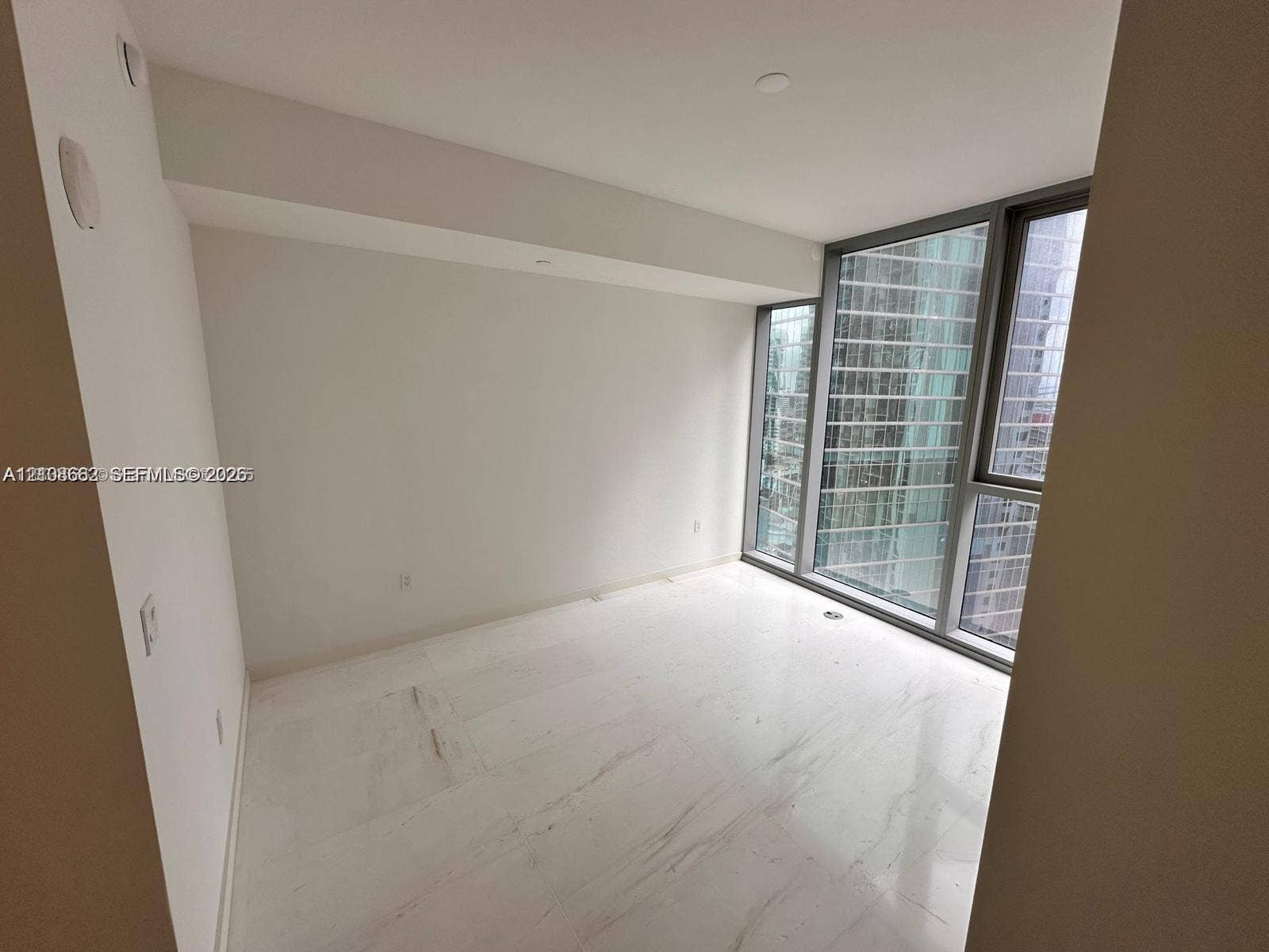 300 Biscayne Boulevard, #2709W, Miami, Miami, FL 33131 Interior room featuring floor-to-ceiling windows with metal framing and polished stone flooring