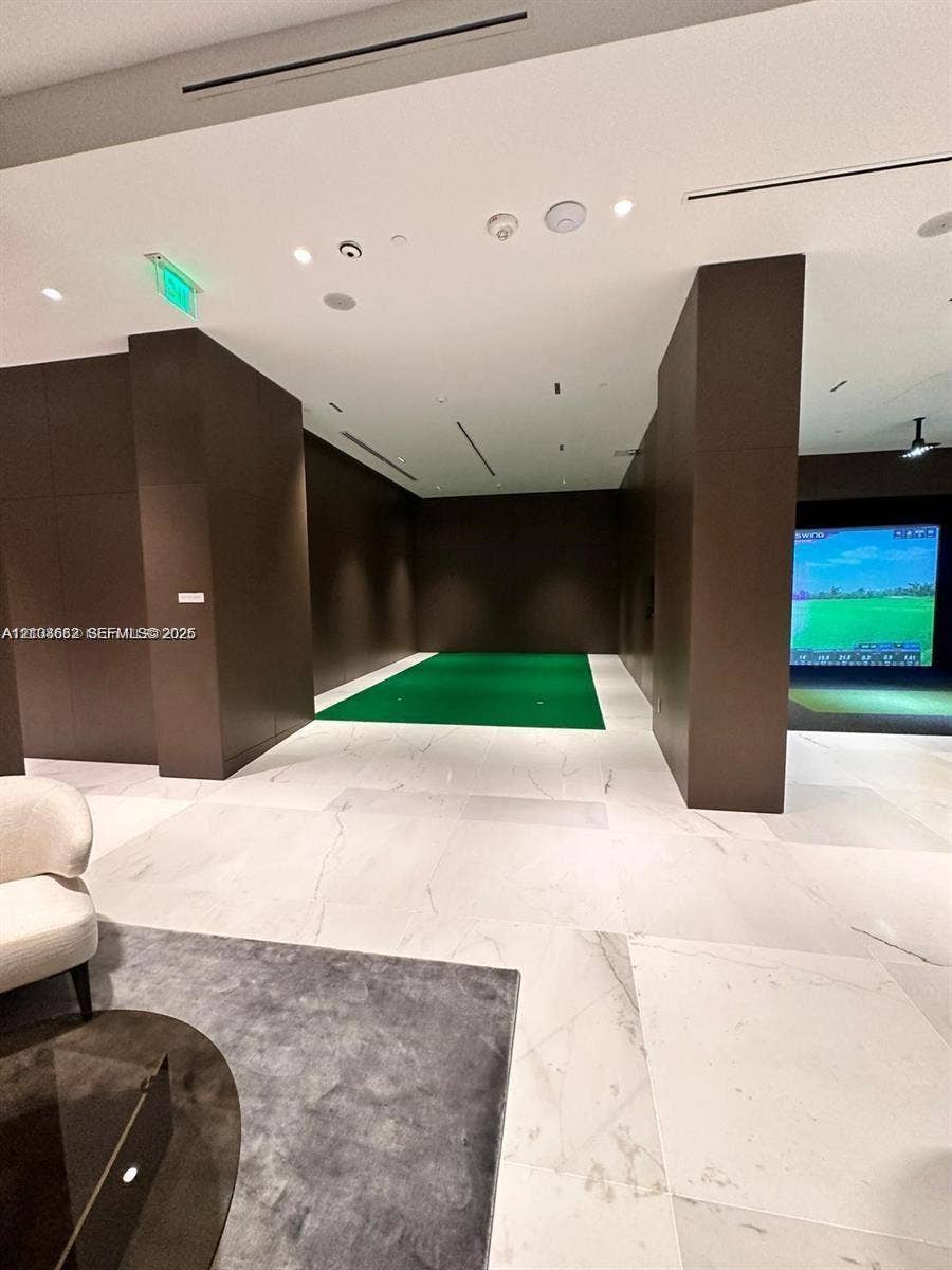 300 Biscayne Boulevard, #2709W, Miami, Miami, FL 33131 Indoor putting green featuring stone-tile flooring, dark wood-paneled walls, and integrated digital golf simulator