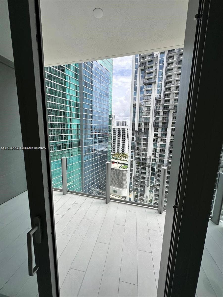 300 Biscayne Boulevard, #2709W, Miami, Miami, FL 33131 Private balcony featuring light-toned, large-format tile flooring and a minimalist glass-panel railing with metal supports