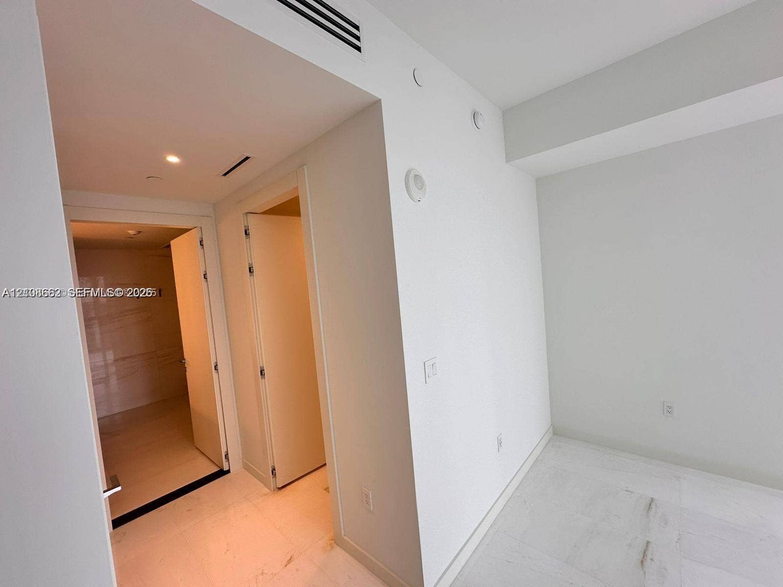 300 Biscayne Boulevard, #2709W, Miami, Miami, FL 33131 Interior space featuring white stone-finish flooring, recessed ceiling lighting, and smooth-finish walls with minimalist door frames
