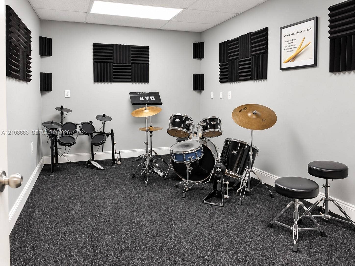 Doral, Doral, FL 33166 Interior room featuring dark carpeting, neutral gray wall paint, and integrated acoustic wall paneling