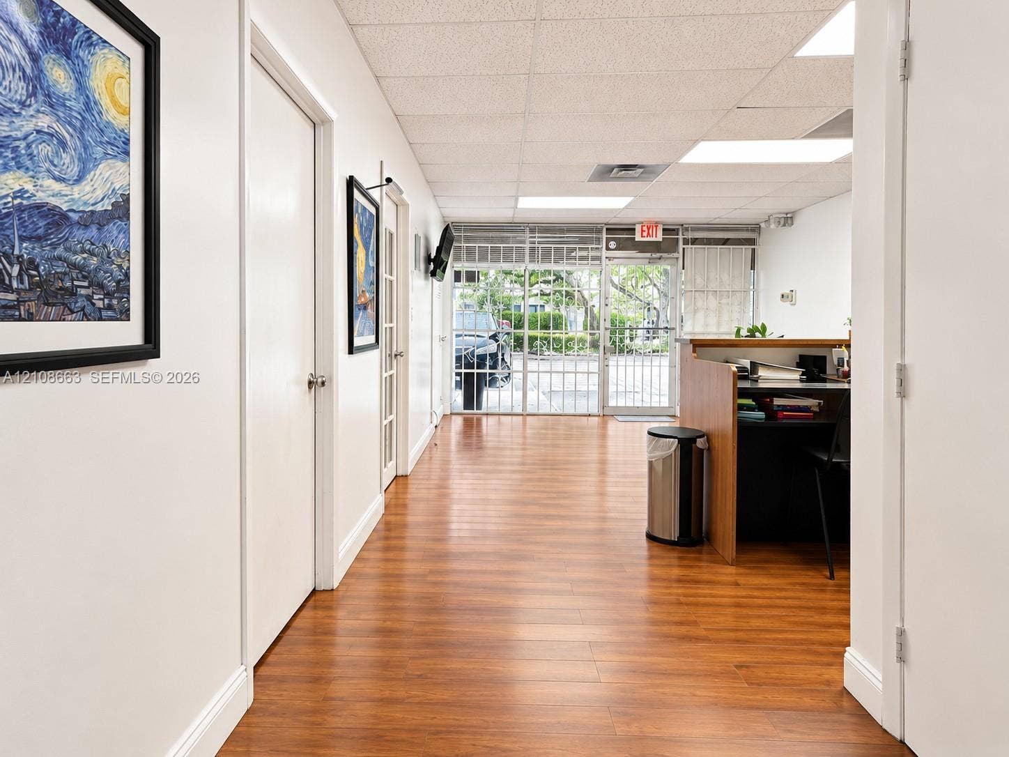 Doral, Doral, FL 33166 Wood-finish flooring, drop ceiling with recessed lighting, integrated wooden reception desk, and floor-to-ceiling glass panel entrance