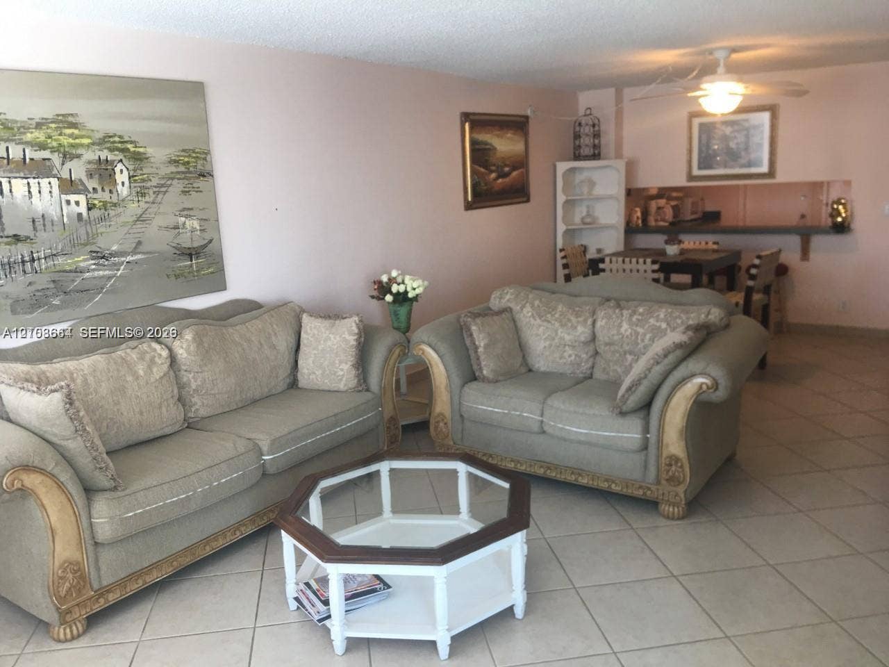 1410 S Ocean Drive, #803, Hollywood, FL 33019 Open-concept interior featuring light-toned tile flooring, built-in shelving, a kitchen pass-through counter, and a ceiling fan